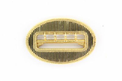a close up of a gold plated hair comb on a white background