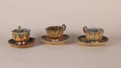 three small cups and saucers sitting on top of a table
