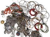 a pile of assorted jewelry on a white surface