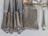 a lot of silver spoons and forks on the table