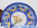 a blue and white plate with a yellow bird on it