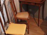 two wooden chairs and a desk in a small room