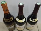 three bottles of wine sitting on the floor next to each other