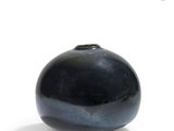 a black vase that is sitting on a white surface