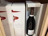 Deux bouteilles de vin sont posées sur une étagère dans un magasin.