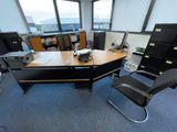 a desk with a chair and a printer in an office