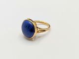 a close up of a gold ring with a lapis stone