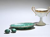 a green bowl and a white cup on a table