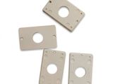 four pieces of white metal with holes on them on a white surface