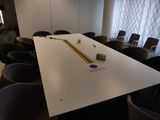 une longue table sur laquelle est posé un crayon, au milieu d'une pièce