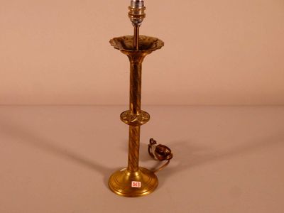 a gold colored lamp that is on a table