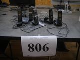 Plusieurs téléphones portables sont posés sur une table, accompagnés d'une étiquette de prix