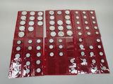 six paquets de pièces rouges et argentées empilés les uns sur les autres