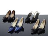 Quatre paires de chaussures pour femmes sont alignées sur une surface noire