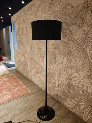 a lamp that is on the floor next to a rug