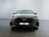 the front of a grey audi suv parked in a white room