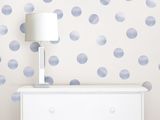 a white dresser sitting in front of a wall covered in blue polka dots