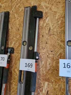 Quatre types différents de quincaillerie pour portes coulissantes sont exposés dans un magasin.