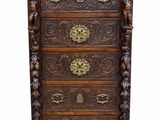 une commode en bois ornée de sculptures raffinées et dotée de poignées en laiton
