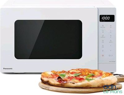 une pizza posée sur une planche à découper à côté d'un micro-ondes