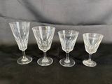 four wine glasses are lined up on a black surface