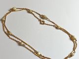 collier avec des perles et une chaîne en or sur fond blanc