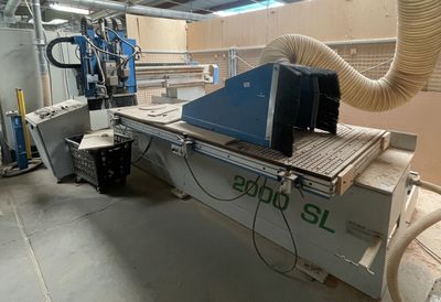 a machine that is cutting a piece of wood in a factory