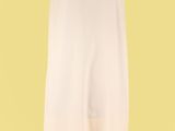 une robe blanche posée sur un mannequin, sur fond jaune