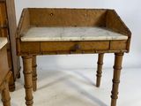 a small wooden table with a marble top on it
