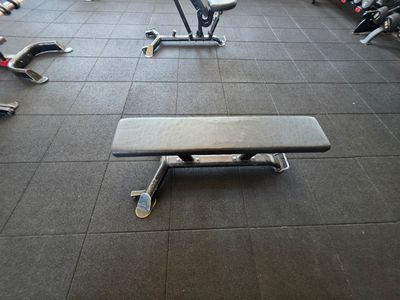 a bench in the middle of a gym with other gym equipment