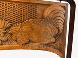 a wooden carving of a rooster and a bird on a bench
