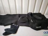a black wet suit and a pair of flip flops on the floor