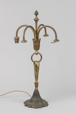 an antique brass candelab with three arms and a candle holder