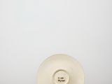 a white plate sitting on top of a table next to a white wall
