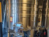 Des cuves en acier inoxydable sont alignées les unes à côté des autres dans une pièce