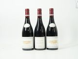 trois bouteilles de vin rouge posées l'une à côté de l'autre sur une surface blanche