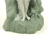 a figurine of a woman sitting on a rock