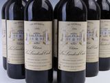 six bottles of wine are lined up in a row on a table
