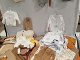 une table sur laquelle sont posés de nombreux vêtements pour bébés