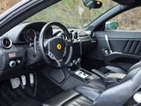 the interior of a black sports car with leather seats and steering controls