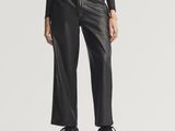 une femme vêtue d'un pantalon en cuir noir et d'un pull à col roulé noir