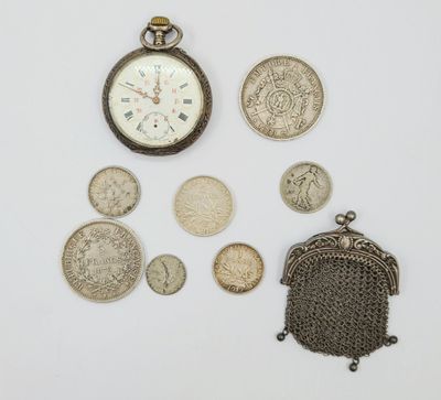 de nombreuses pièces de monnaie et une montre de poche posées sur une surface blanche