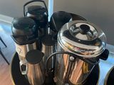 a tray with coffee pots and cups on it