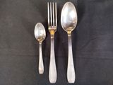 three spoons and a fork sitting on a table