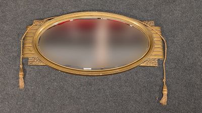un miroir doré auquel sont suspendus des pompons
