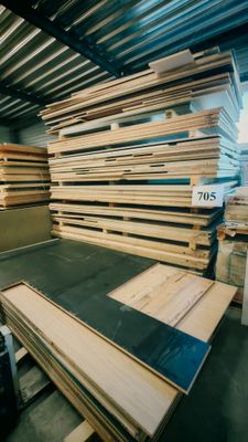un homme qui se tient debout devant un tas de bois