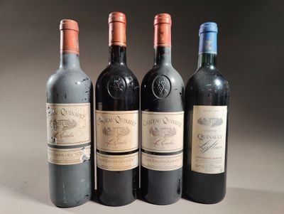 quatre bouteilles de vin sont alignées sur une table