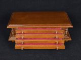a small wooden box with three drawers on top of it