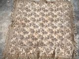 an old rug with fringes and a floral design on it