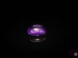 une image représentant une boule de cristal violette posée sur une surface noire